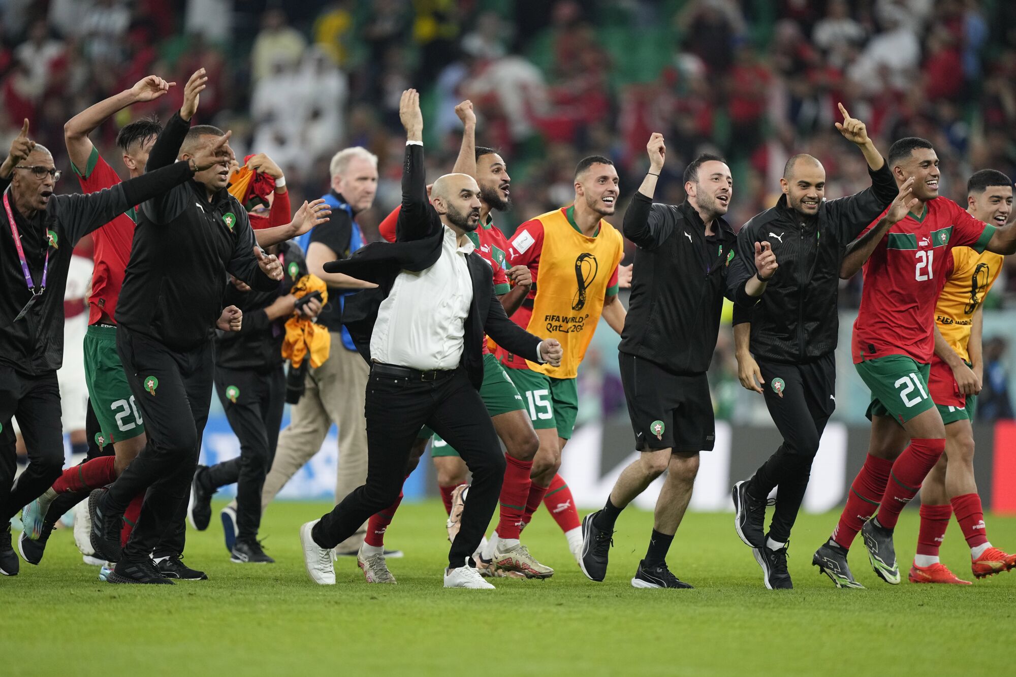 L'entraîneur de l'équipe nationale marocaine Walid Regragui, à l'avant, et ses joueurs et son staff ont célébré leur victoire contre le Portugal