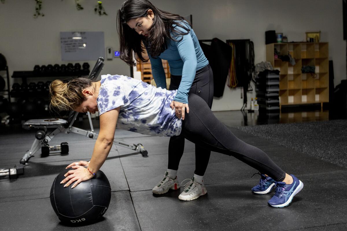 Coach Karen Aceves works with client Liliana Del Aguila at Babes of Wellness gym in Compton, Calif. on Feb. 9, 2024.