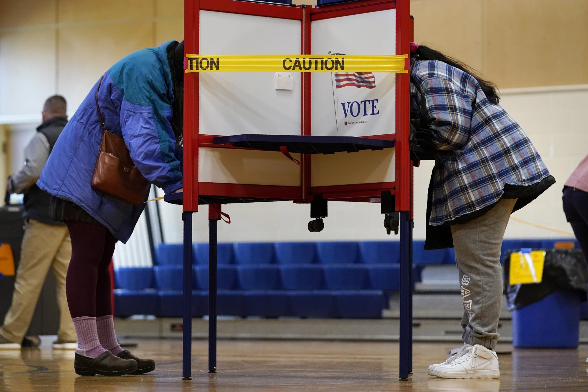 Caution tape closes off a voting stall at the East End School in Portland, Maine, to help distance voters.