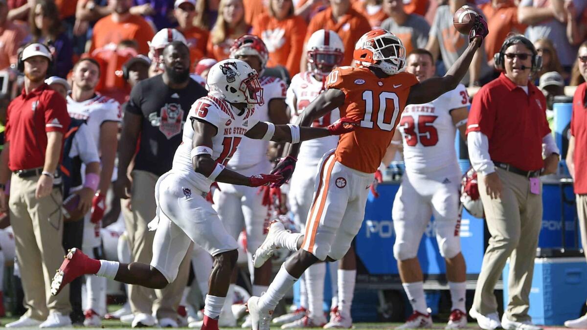 Clemson's Derion Kendrick (10) tries a one-handed catch while defended by North Carolina State's Chris Ingram during the first half on Saturday.