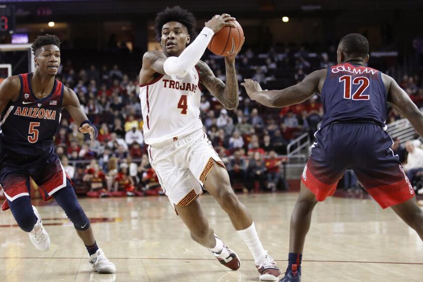 Southern California's Kevin Porter Jr., center, drives between Arizona's Brandon Randolph, left, and Justin Coleman during the first half of an NCAA college basketball game, Thursday, Jan. 24, 2019, in Los Angeles. (AP Photo/Jae C. Hong)