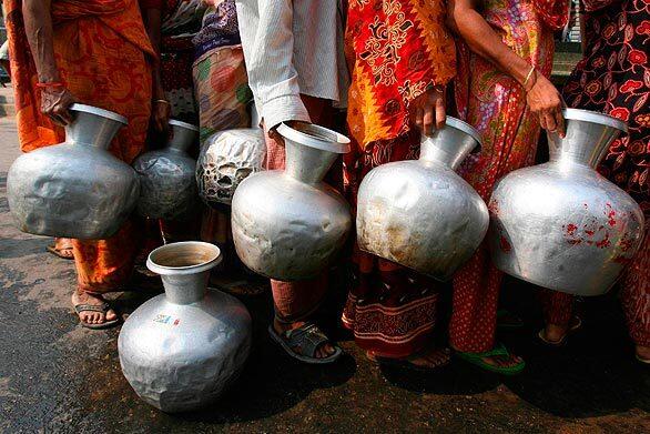 Women line up to collect water at a roadside tap in an impoverished neighborhood of Dhaka, the capital of Bangladesh. There is no direct supply of potable water to homes in many areas of Dhaka, and a single tap may be used by hundreds of households.