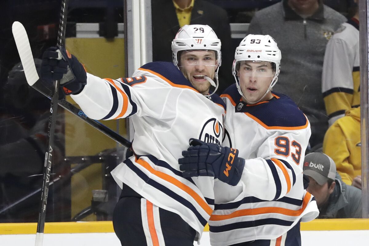 Edmonton Oilers center Leon Draisaitl (29), of Germany, celebrates with Ryan Nugent-Hopkins (93) after Draisaitl scored his second goal of the game against the Nashville Predators in the third period of an NHL hockey game Monday, March 2, 2020, in Nashville, Tenn. (AP Photo/Mark Humphrey)
