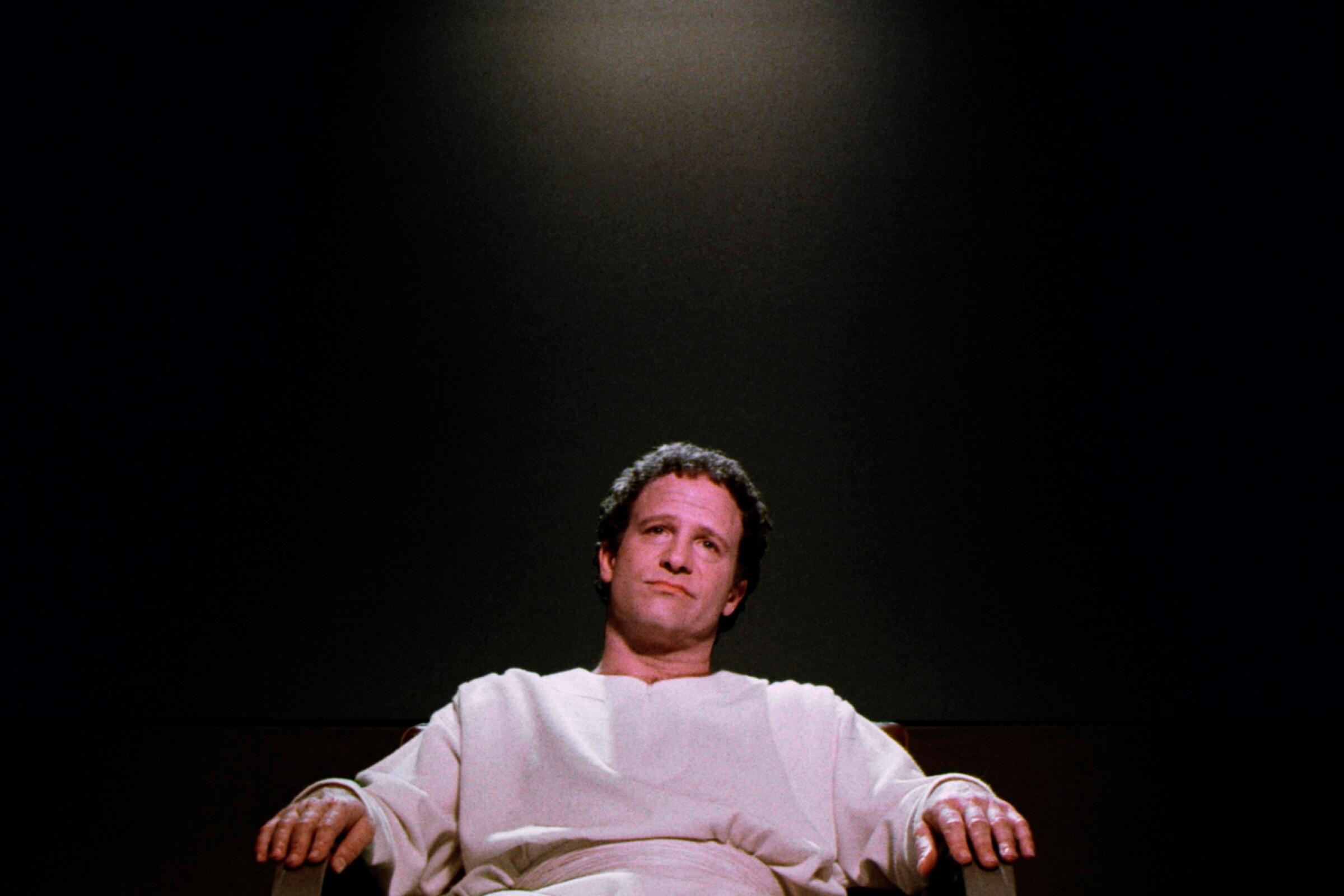 Albert Brooks sitting in a chair in "Defending Your Life."