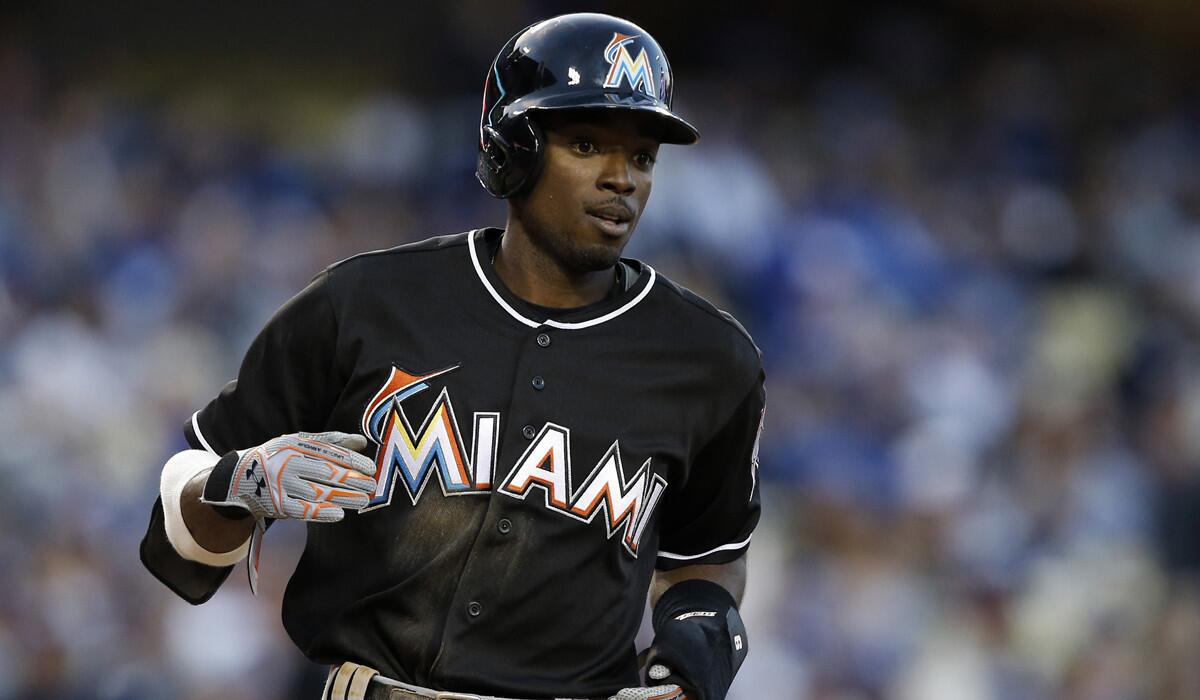 The Miami Marlins' Dee Gordon makes his way to the dugout after scoring against the Dodgers during the first inning on Wednesday.