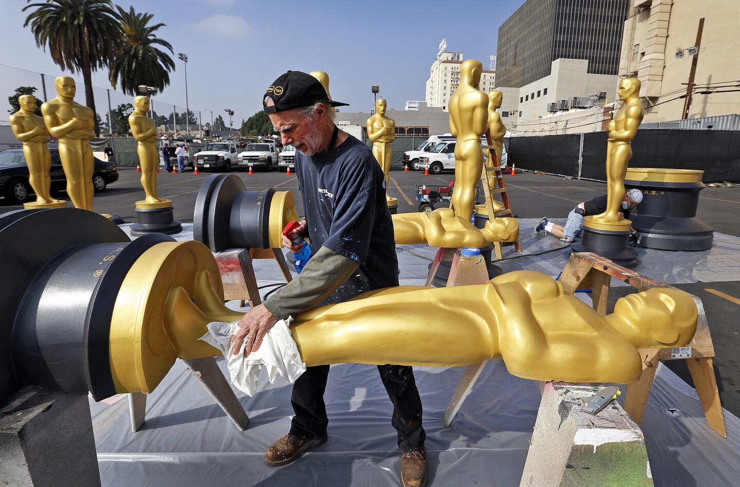 Scenic artist Sam Costa on Tuesday prepares one of the many Oscar statues that will receive a new coat of paint before being placed around the Hollywood & Highland complex this week in anticipation of Sunday's Academy Awards ceremony at the Dolby Theatre.