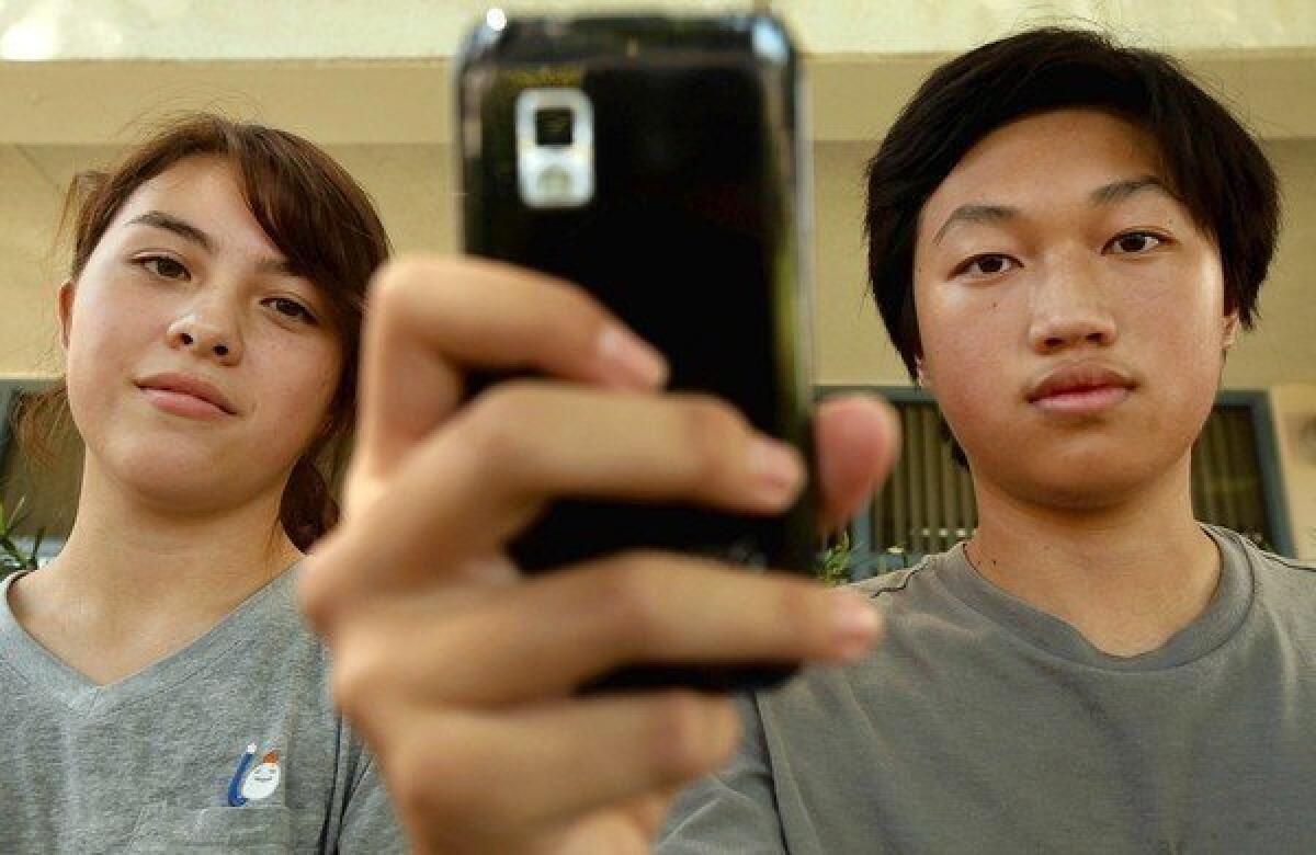GLENDALE, CA - SEPTEMBER 12, 2013: Portrait of Young Cho, left, 16, of Glendale and Christopher Chung, right,16, also of Glendale in front of their school Herbert Hoover High School in Glendale, CA September 12, 2013. The Glendale Unified School District, in an effort to reach out to students at risk of harming themselves and try to quell bullying at its schools, hired a company last month to monitor the social media accounts of its 13,000 middle and high school students. The company scrutinize public posts from accounts associated with students - reporting to school officials posts indicating issues ranging from suicidal thoughts and abuse, to vandalism and use of obscenities. ( Francine Orr/ Los Angeles Times)