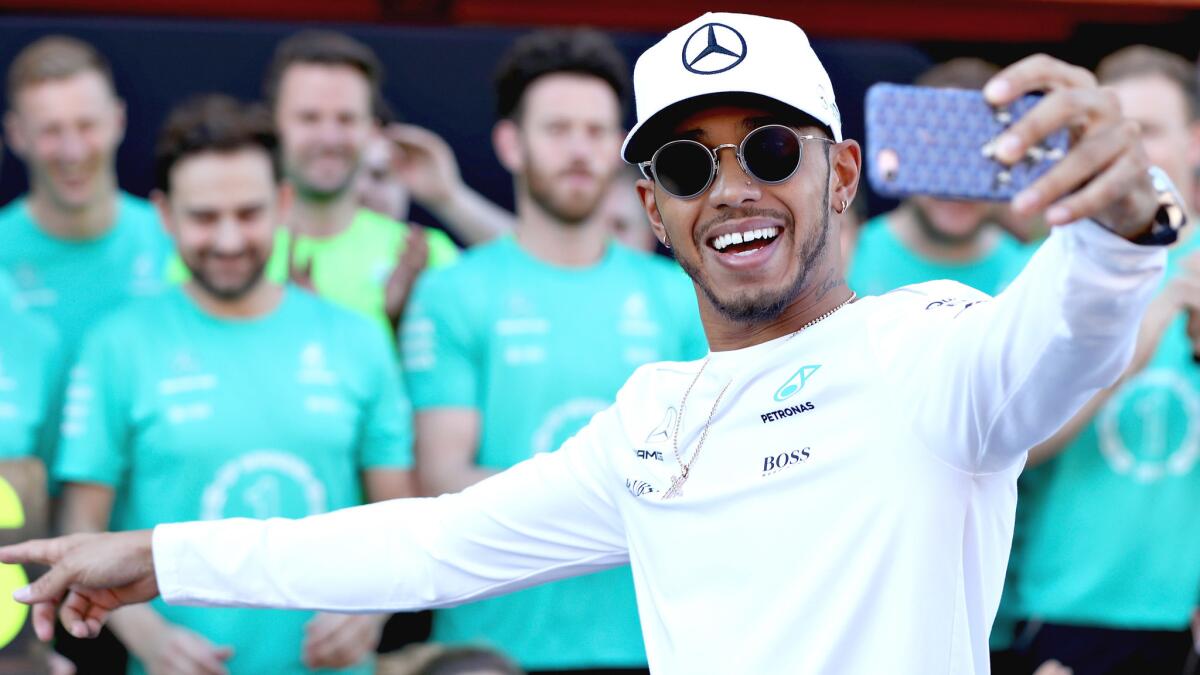 Formula One driver Lewis Hamilton takes a selfie with his Mercedes team to celebrate his win at the Spanish Grand Prix on Sunday at Circuit de Catalunya.