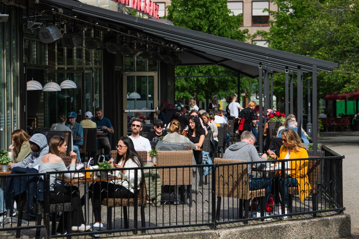 People sit at tables outside.