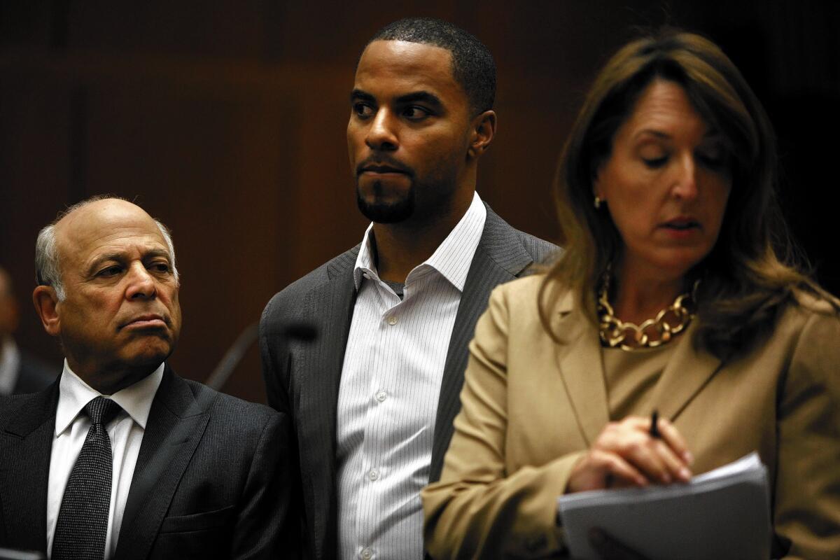Flanked by attorneys Leonard Levine, left, and Blair Berk, former NFL player Darren Sharper appears in court in Los Angeles on charges of drugging and sexually assaulting two women. Prosecutors said he's also under investigation for allegedly attacking at least five other women in three other states.