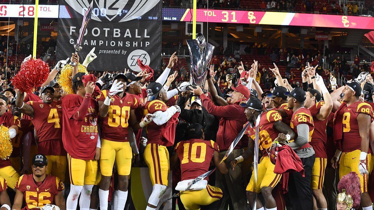 USC coach Clay Helton holds up the Pac-12 championship trophy after the Trojans beat Stanford at Levi's Stadium in 2017.
