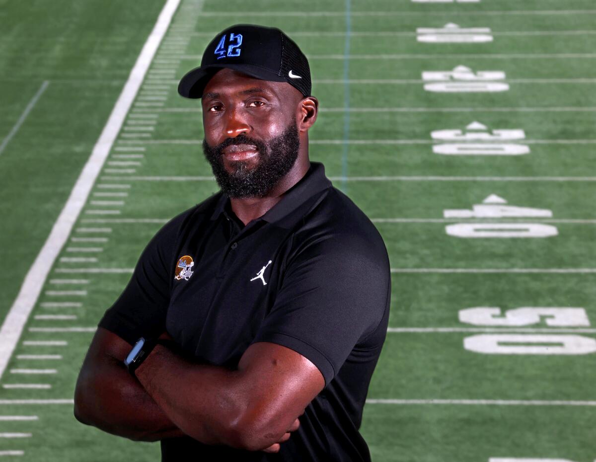 UCLA coach DeShaun Foster crosses his arms and smiles slightly while posing for a portrait 