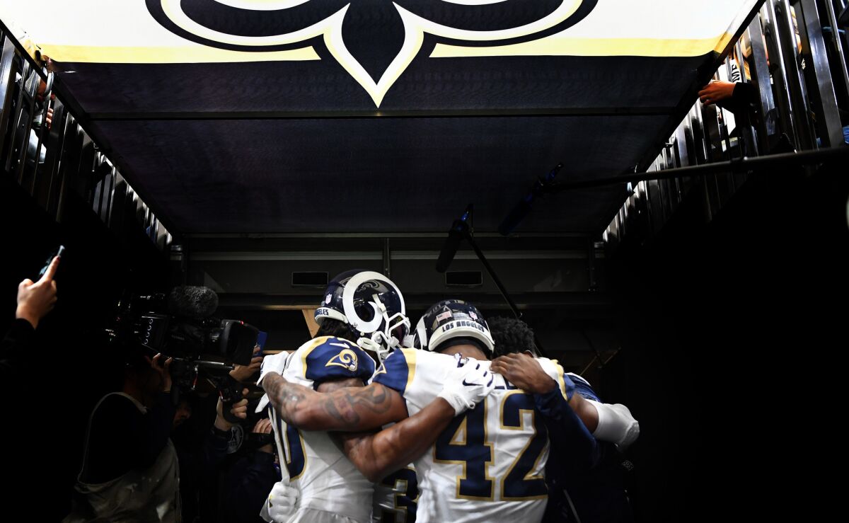 The Rams running backs huddle before a game between the Rams and Saints in the NFC Championship in New Orleans on Jan. 20.