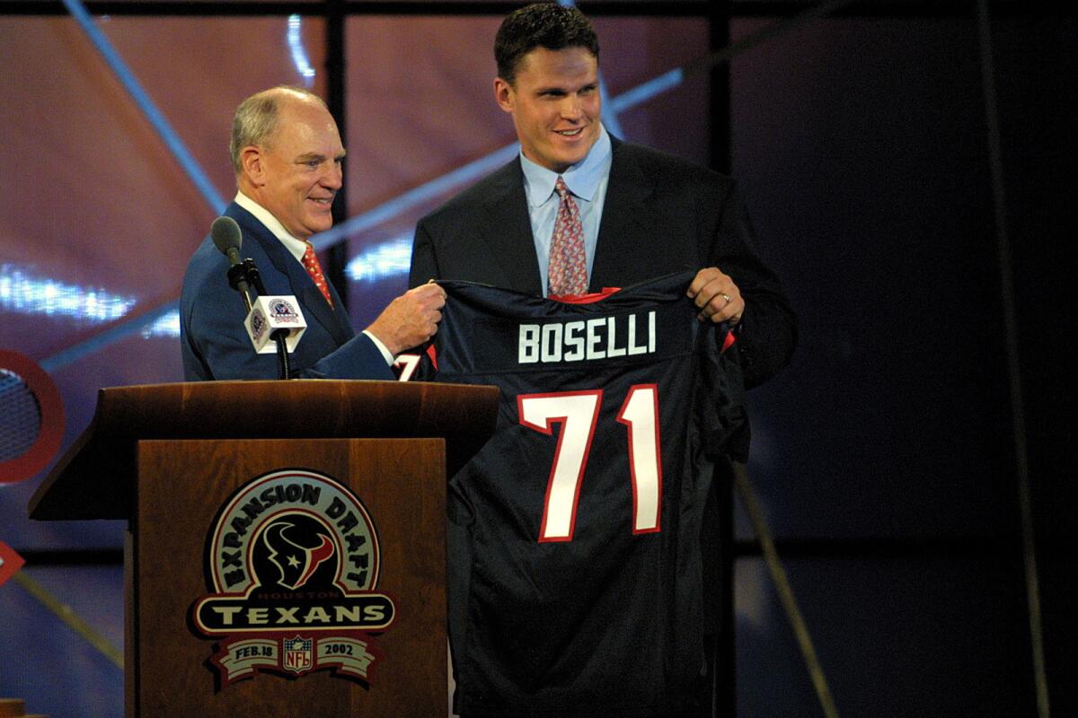 Team owner Bob McNair presents a jersey to Tony Boselli during the Houston Texans expansion draft on Feb. 18, 2002.