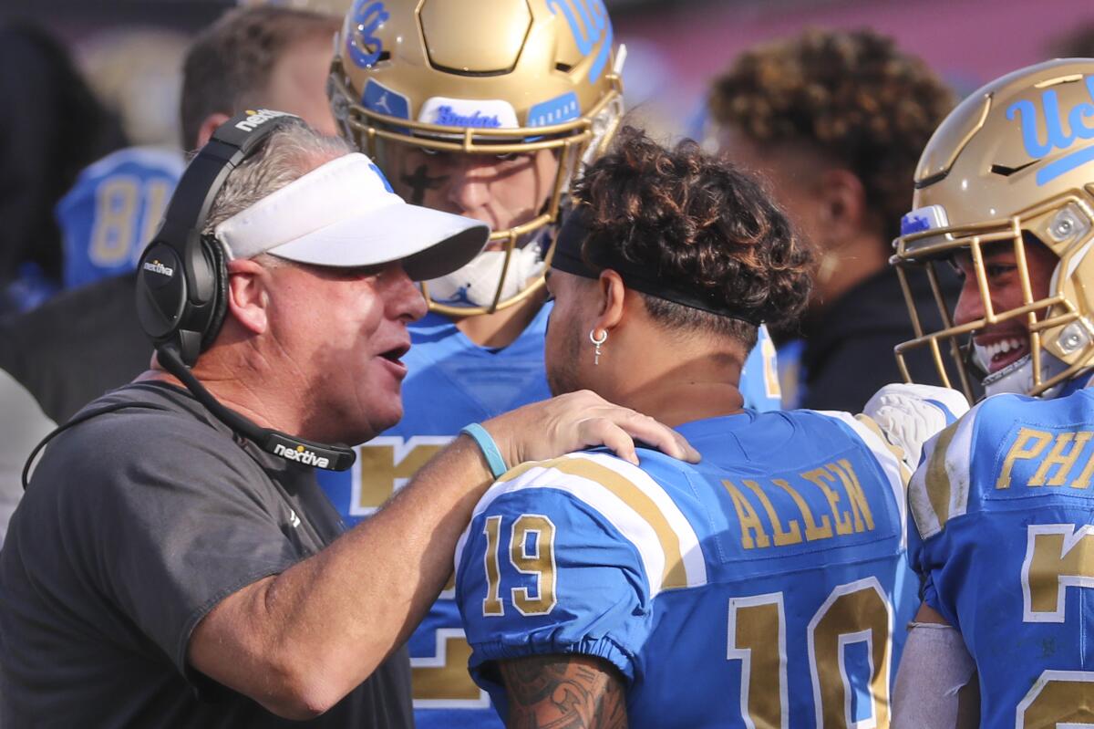 UCLA head coach Chip Kelly, left, congratulates UCLA running back Kazmeir Allen after his first quarter touchdown.