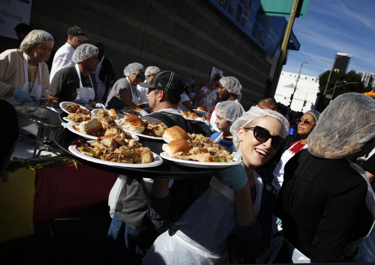 Volunteer Michelle Hacker carries Thanksgiving meals to guests at the Midnight Mission in downtown Los Angeles.
