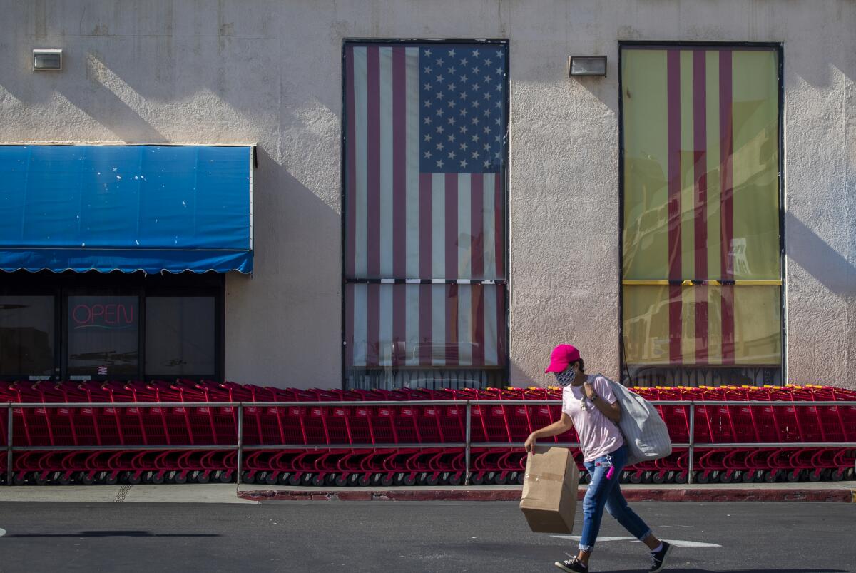 A shopper wearing a protective mask walks by a Dong Supermarket in Westminster.