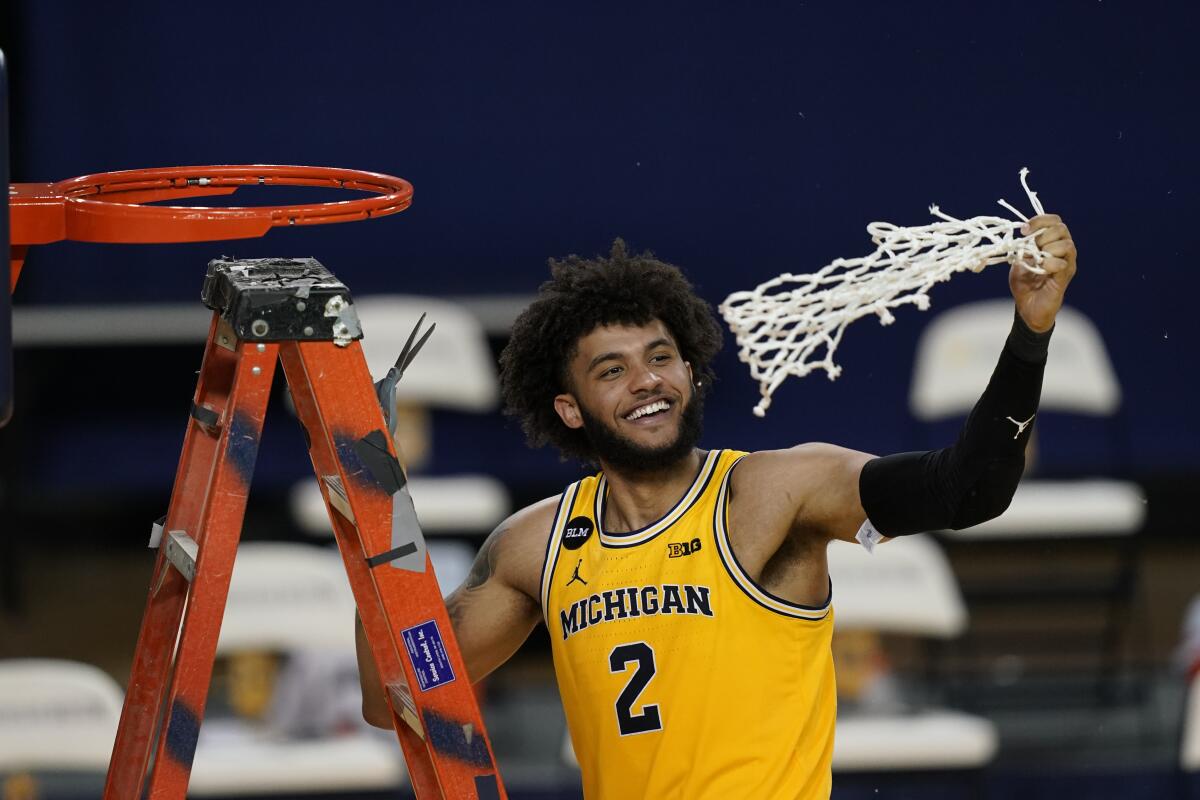 Michigan forward Isaiah Livers twirls the net after the team won the Big Ten title against Michigan State in the second half of an NCAA college basketball game, Thursday, March 4, 2021, in Ann Arbor, Mich. (AP Photo/Carlos Osorio)