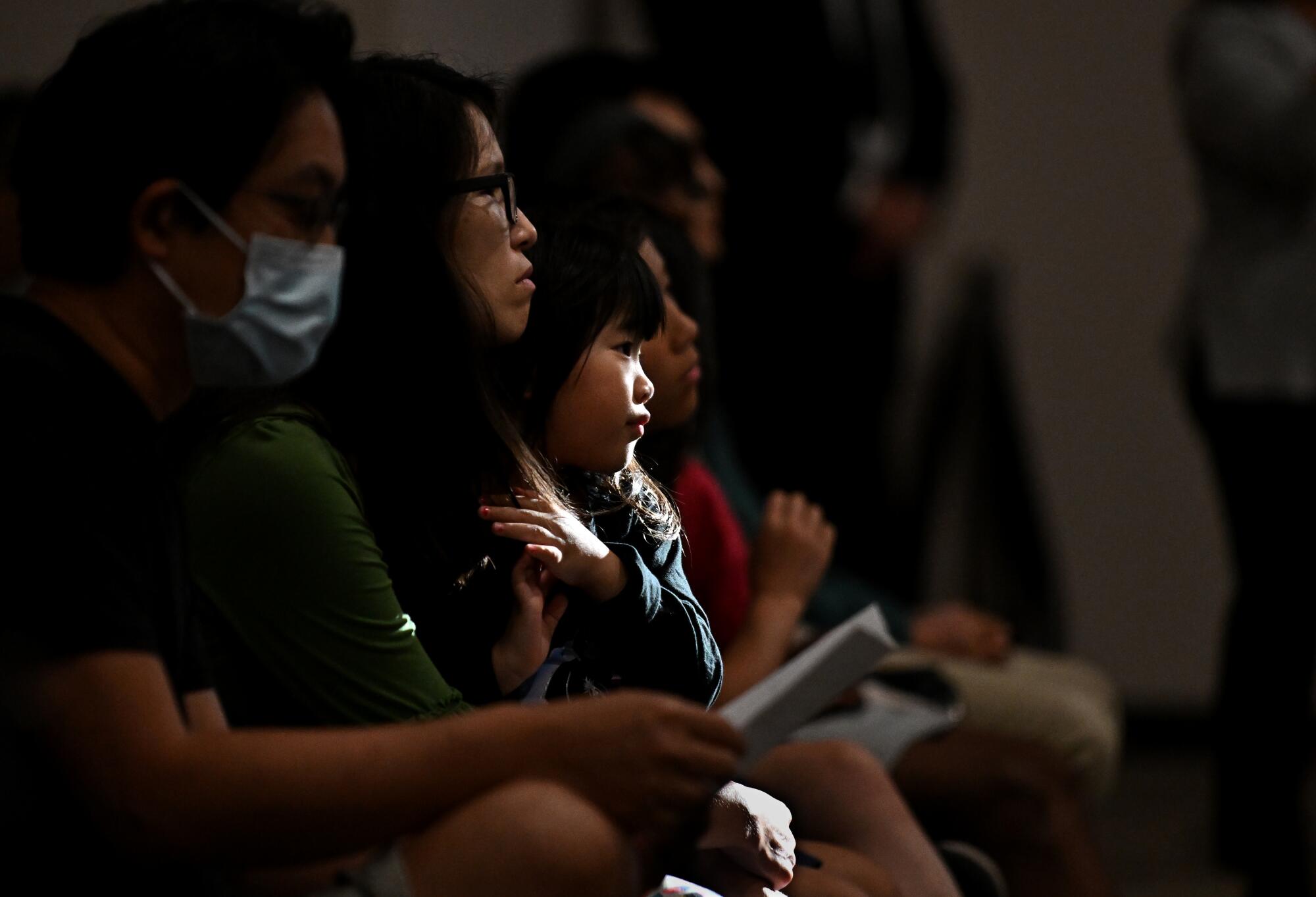 Worshippers listen to speakers and pray during a vigil at Christ Our Redeemer Church in Irvine Monday.