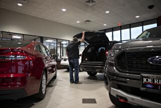 A customer looks over an SUV at a car dealership in Orland Park, Illinois.