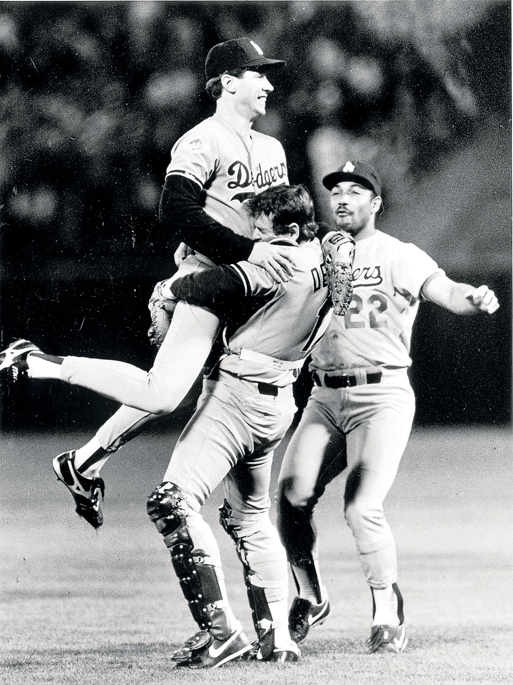 Rick Dempsey lifts Orel Hershiser in celebration at the conclusion of the 1988 World Series. Franklin Stubbs is on the right.