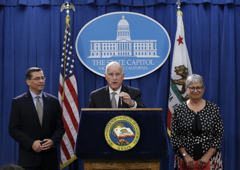 Gov. Jerry Brown, flanked by state Atty. Gen. Xavier Becerra, left, and California Air Resources Board Chair Mary Nichols