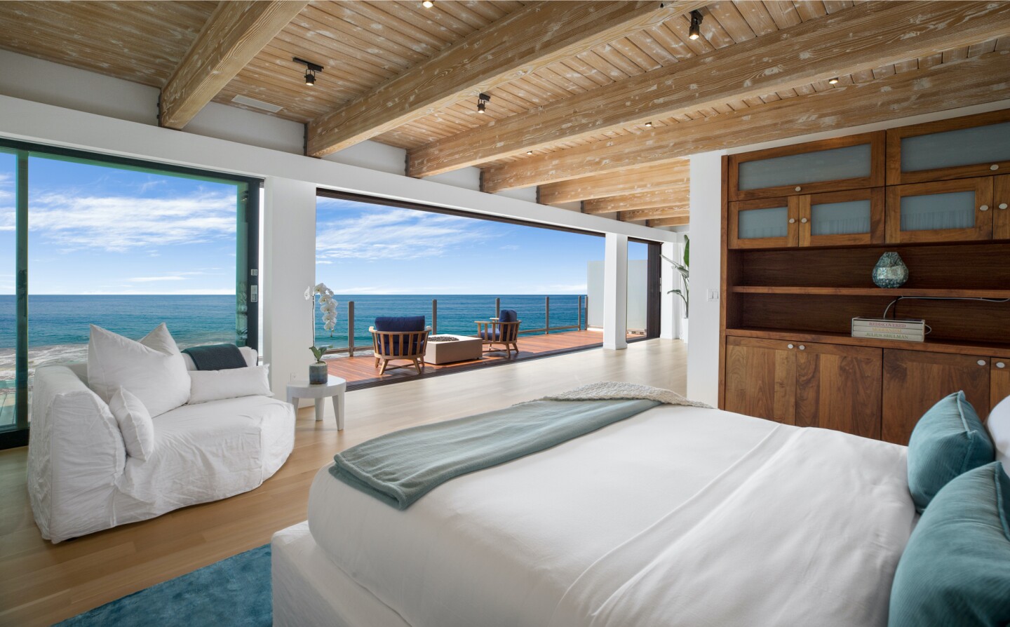 The architectural beach house expands to two levels of wood decks overlooking the ocean.