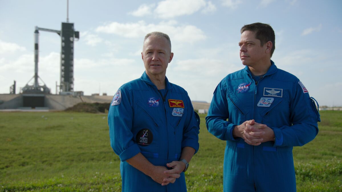Astronauts Doug Hurley, left, and Bob Behnken in blue NASA jumpsuits in the documentary “Return to Space.”
