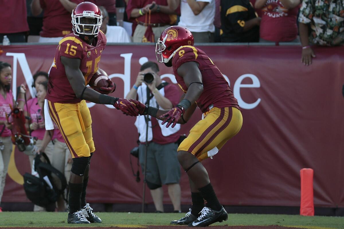 USC's Nelson Agholor and Juju Smith exchange a celebratory handshake after Agholor scored on a 75-yard touchdown pass from Cody Kessler during the third quarter of the Trojans' 56-28 victory over Colorado on Saturday at the Coliseum.
