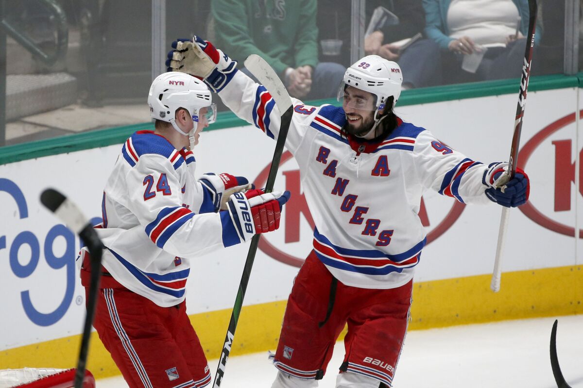 New York Rangers right wing Kaapo Kakko (24) celebrates with center Mika Zibanejad (93) after Kakko scored against the Dallas Stars during the second period of an NHL hockey game in Dallas, Tuesday, March 10, 2020. (AP Photo/Michael Ainsworth)