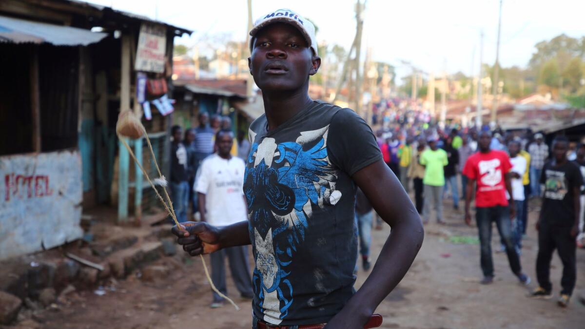An opposition supporter in Kenya holds a sling during clashes with riot police after Uhuru Kenyatta was declared president by the Independent Electoral and Boundaries Commission.