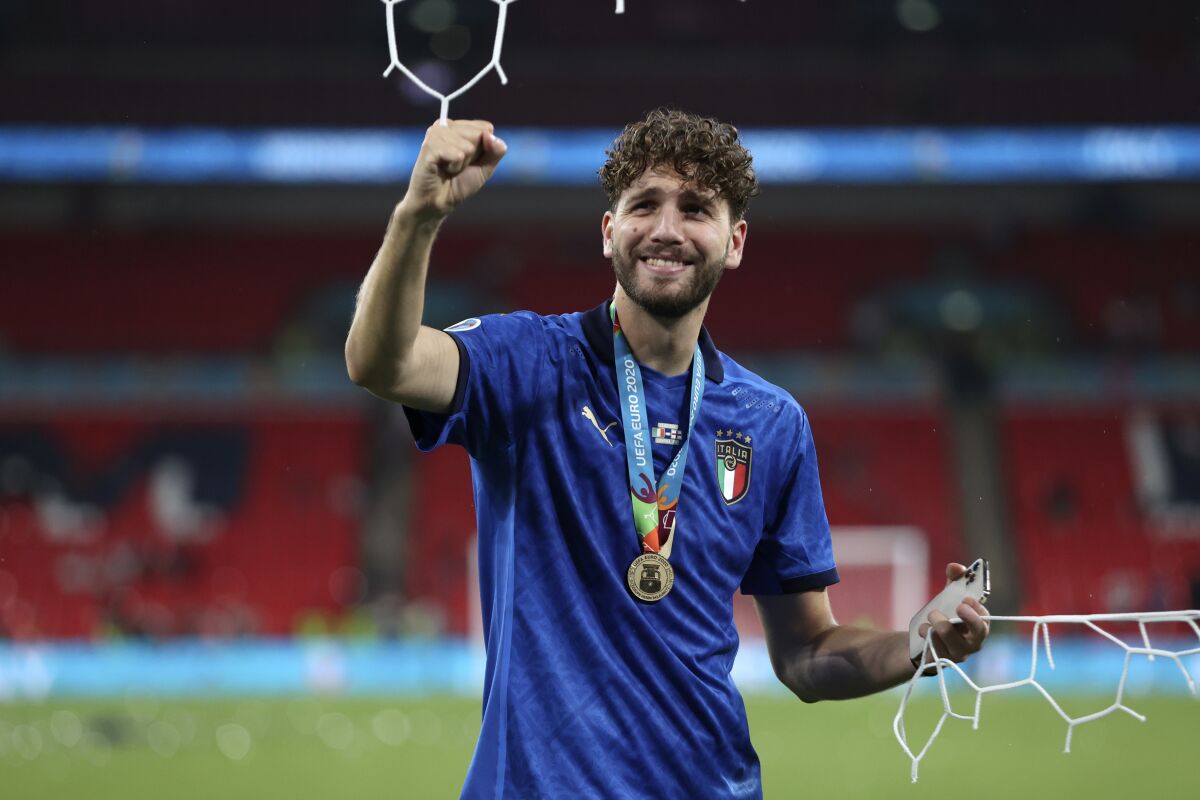 FILE - In this Sunday, July 11, 2021 file photo Italy's Manuel Locatelli celebrates while holding a piece of the goal net after Italy won the Euro 2020 soccer championship final match between England and Italy at Wembley stadium in London. Juventus completed the signing of Italy midfielder Manuel Locatelli from Sassuolo on Wednesday Aug. 18, 2021 just over a month after he helped the Azzurri win the European Championship. (Carl Recine/Pool Photo via AP, file )