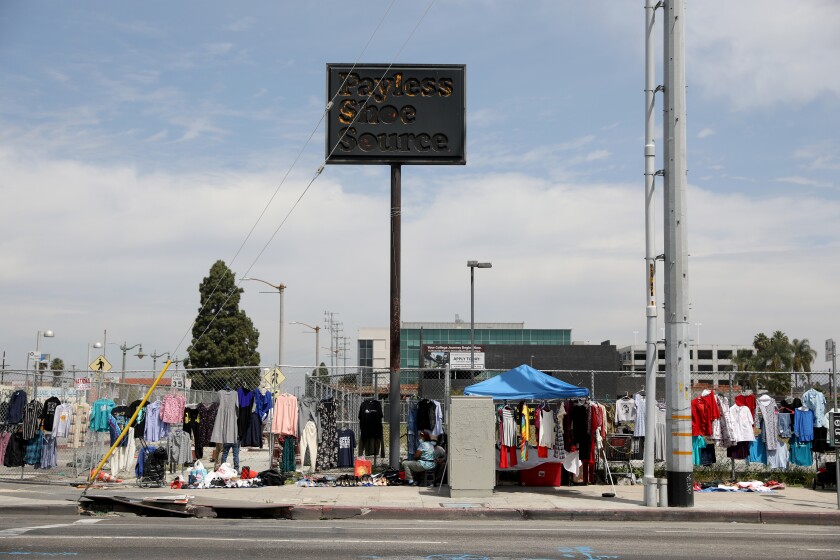 A charred sign of a former Payless Shoe Source at a street corner