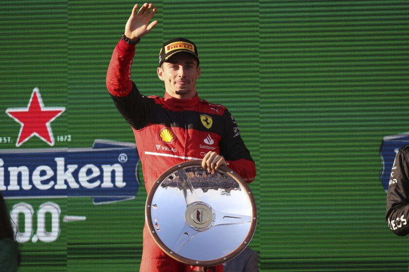 Ferrari driver Charles Leclerc of Monaco waves on the podium after winning the Australian Formula One Grand Prix in Melbourne, Australia, Sunday, April 10, 2022. (AP Photo/Asanka Brendon Ratnayake)