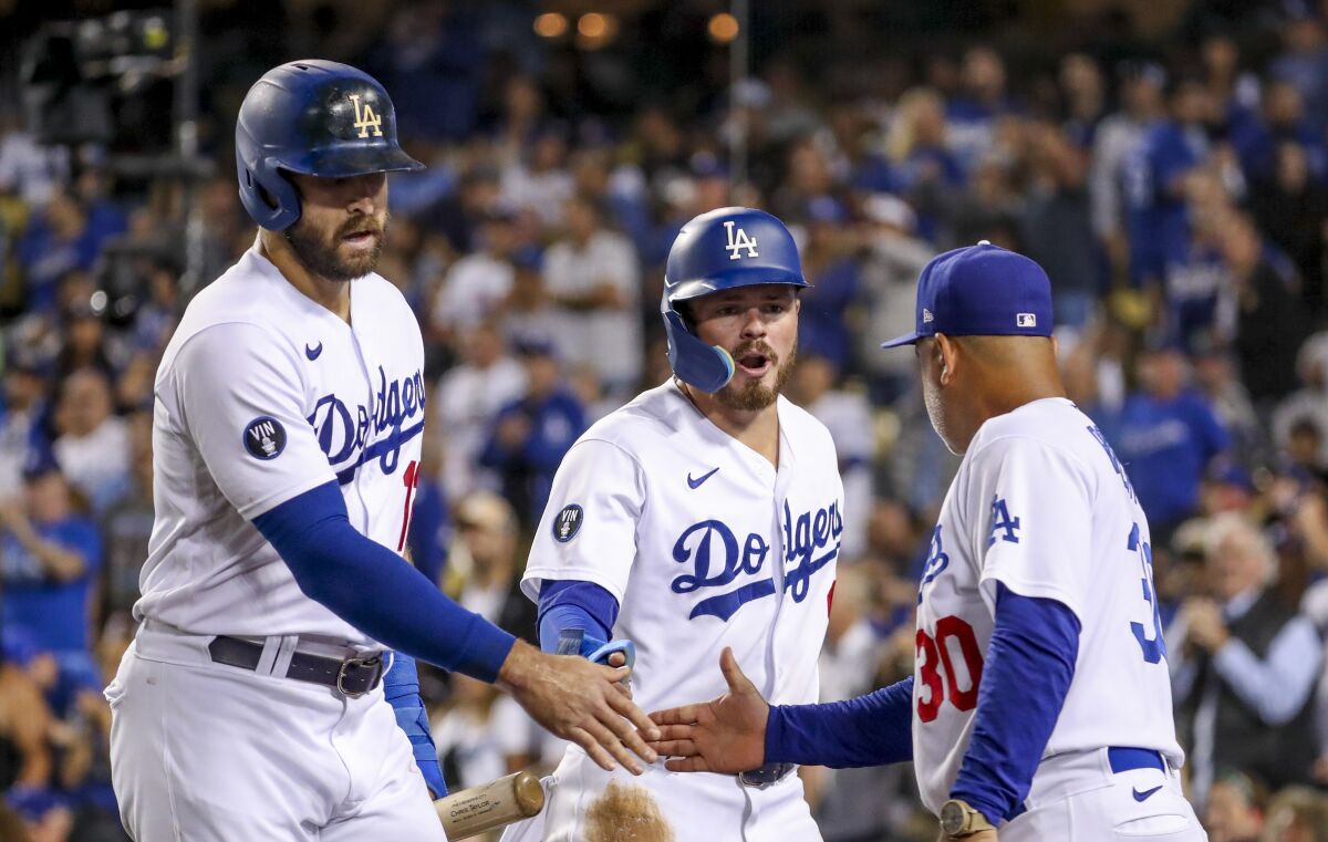 Dodgers' Joey Gallo celebrates with Gavin Lux and manager Dave Roberts after scoring on a home run by Chris Taylor.