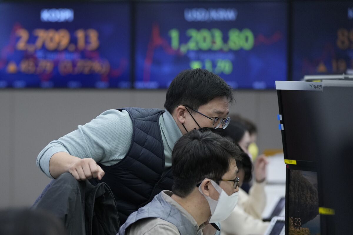 Currency traders watch monitors at the foreign exchange dealing room of the KEB Hana Bank headquarters in Seoul, South Korea, Thursday, Feb. 3, 2022. Shares were mixed in Asia on Thursday as the latest batch of company earnings reports kept investors in a buying mood, driving gains on Wall Street. (AP Photo/Ahn Young-joon)