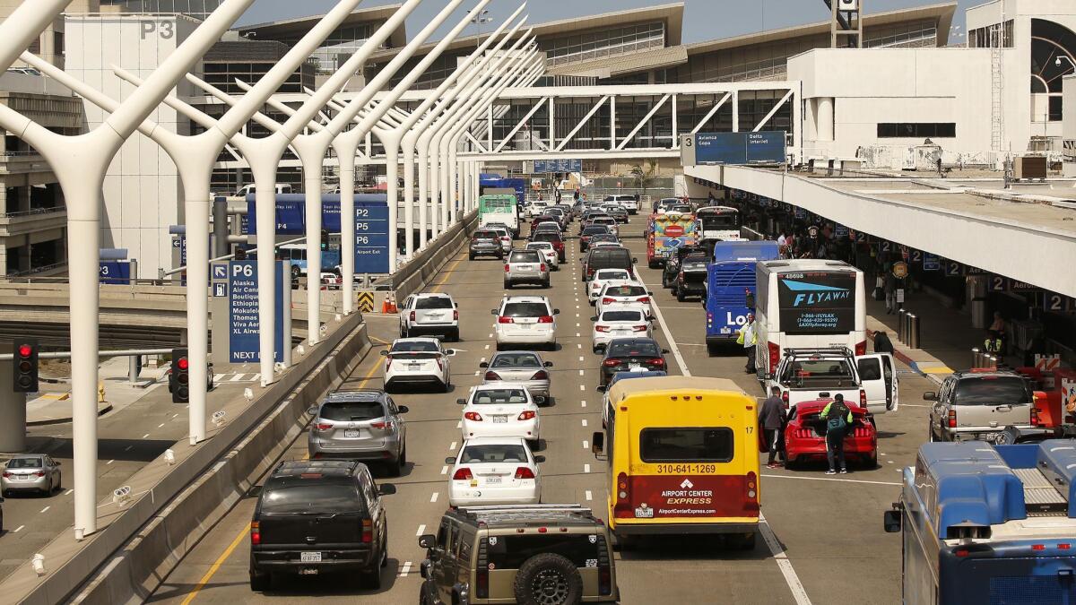 Motorists make their way through Los Angeles International Airport on May 31. Car-sharing company Turo is suing LAX, claiming the airport is under pressure from Enterprise Rent-a-Car to force Turo to pay the same fees that rental car companies pay.