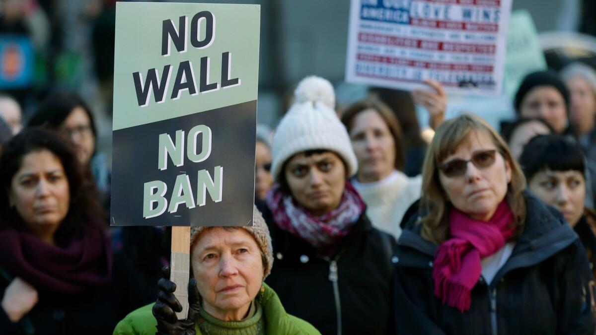 Annie Phillips of Burien, Wash., holding sign, joins a protest Wednesday outside a federal courthouse in Seattle.