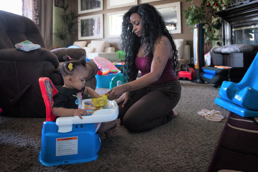 Denise Williams, of Adelanto, cares for her 1-year-old daughter Gigi Williams.