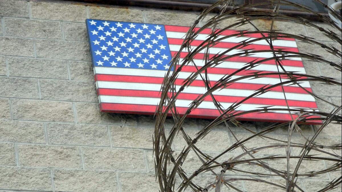 The American flag hangs behind barbed wire at the U.S. Naval Base in Guantanamo Bay, Cuba. Supreme Court Justice Stephen G. Breyer has suggested that the indefinite detention of enemy combatants at Guantanamo may violate the U.S. Constitution.