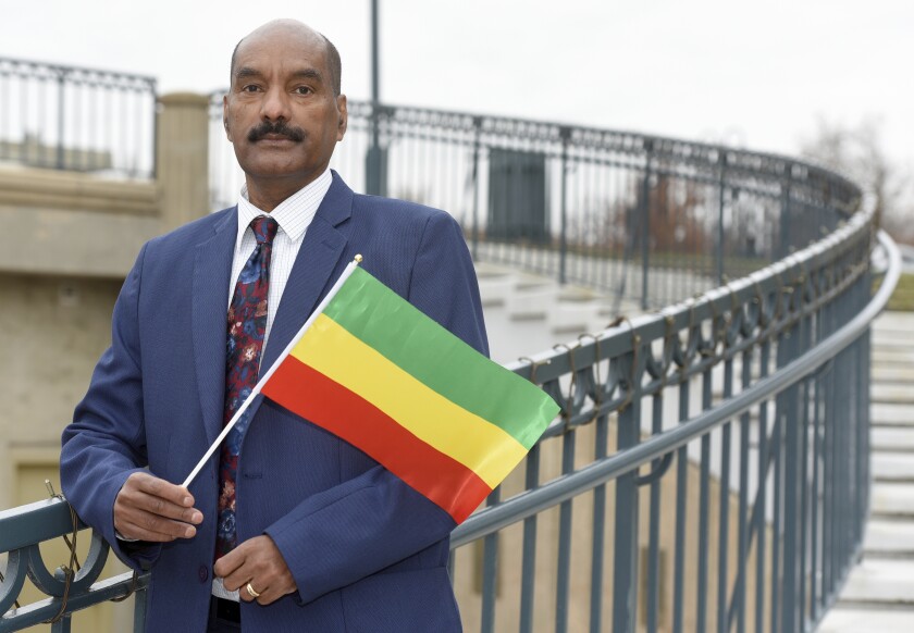 Negasi Beyene, who grew up in Mekele, the capital city of the Ethiopia's Tigray Region, holds a traditional Ethiopian flag Saturday, Dec. 18, 2021 in Columbia, Md. Beyene, who works as a biostatistician near Washington, identifies as a human rights activist for Ethiopian unity. “My motto is, ‘humanity before ethnicity.’” (AP Photo/Steve Ruark)