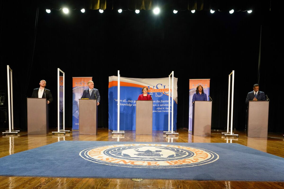 Candidates stand at lecterns before a debate at Virginia State University.