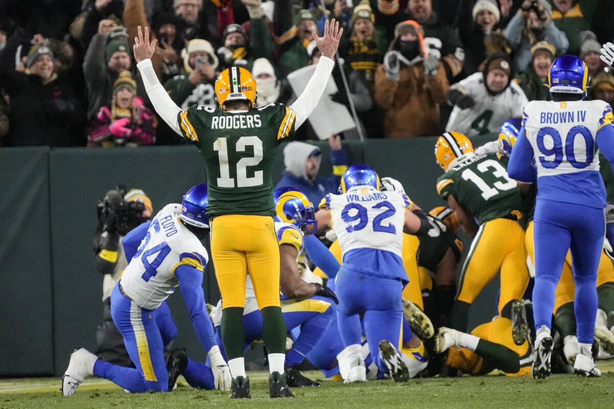 Packers quarterback Aaron Rodgers (12) signals a rushing touchdown for AJ Dillon (28) against the Rams.
