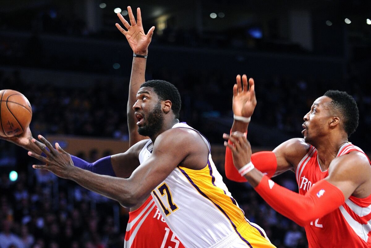 Lakers' Roy Hibbert, left, drives by Houston Rockets' Dwight Howard in the first quarter at the Staples Center on Sunday.