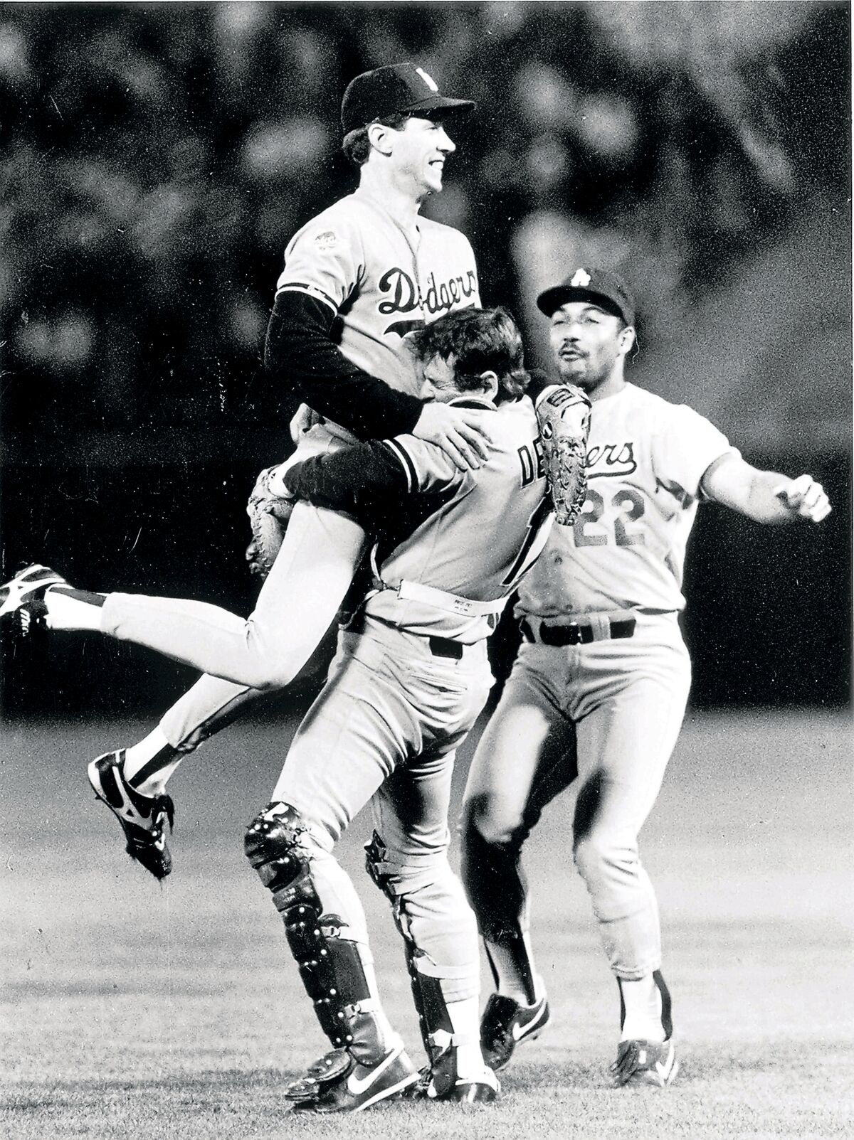 Rick Dempsey lifts Orel Hershiser after winning the 1988 World Series. Franklin Stubbs is ready to join.