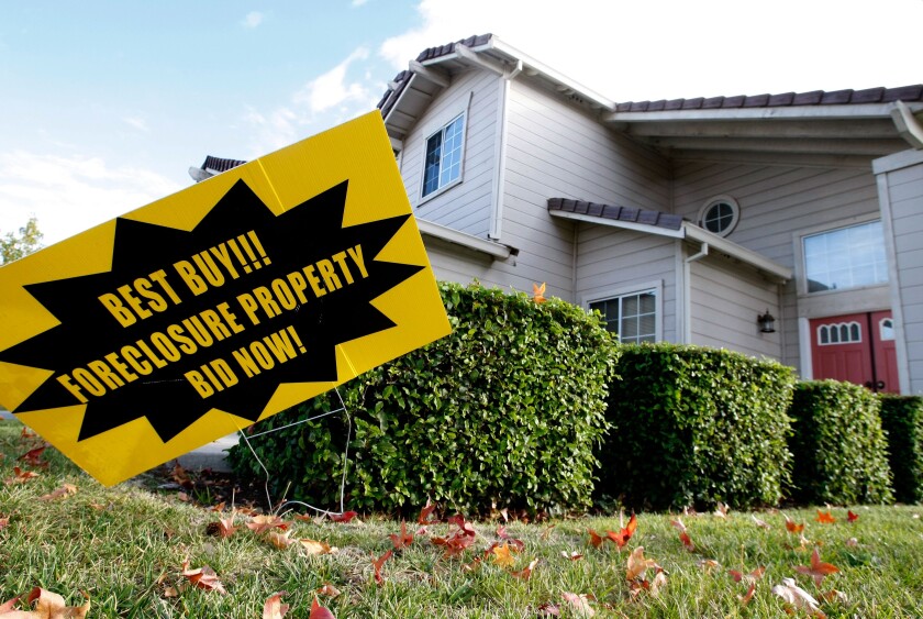 Se ve un letrero de venta de ejecución hipotecaria frente a una casa embargada en Michigan en 2007.