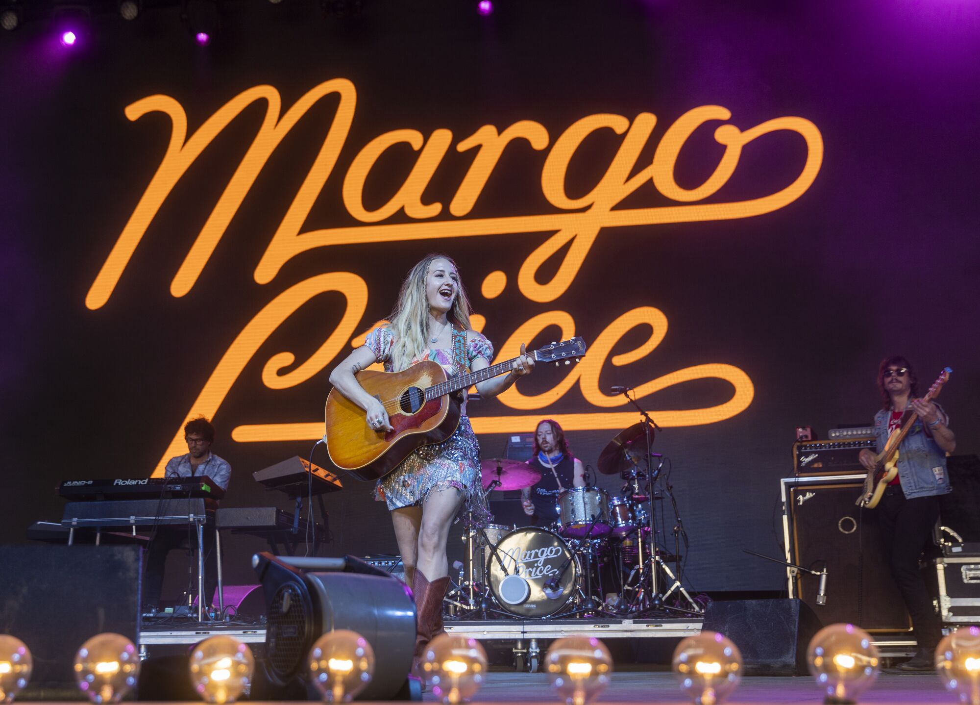 Margo Price plays the guitar and sings onstage