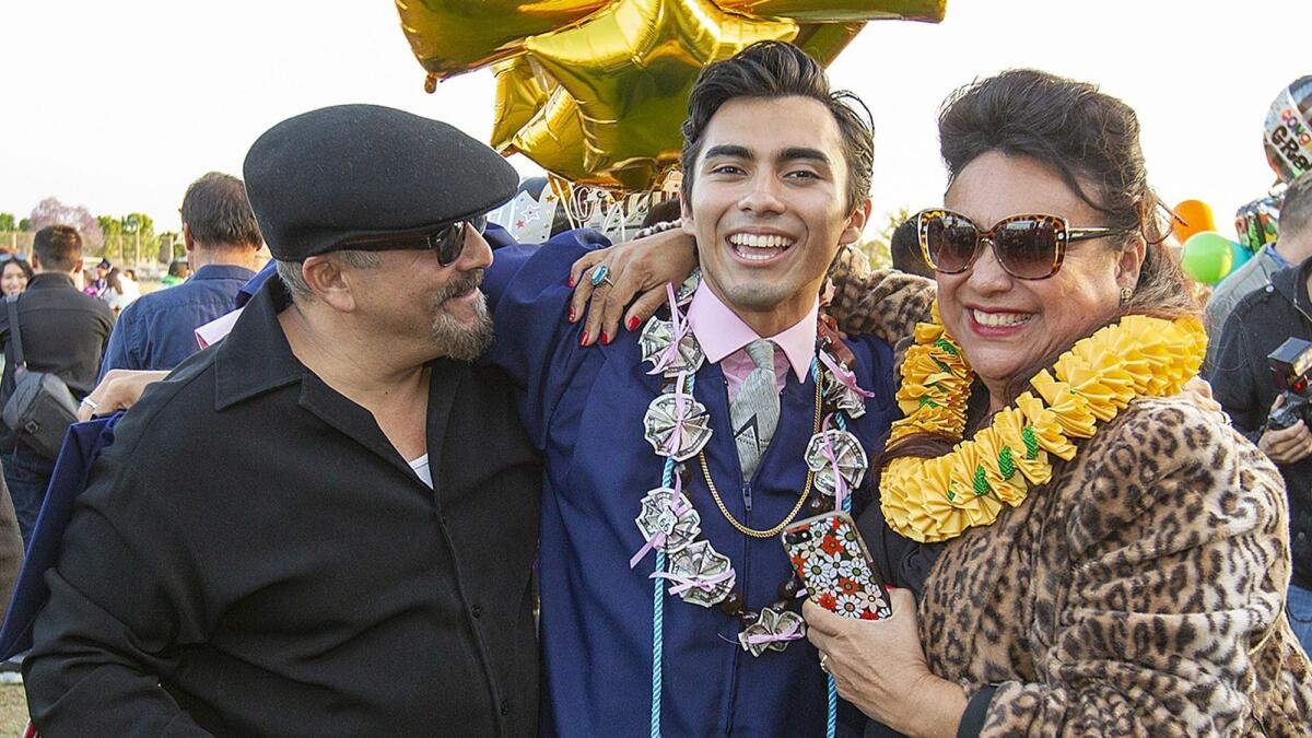 Johnny Ramos celebrates with his father, Kid Ramos, and mother, Linda, following a graduation ceremony from Oxford Academy on May 23.