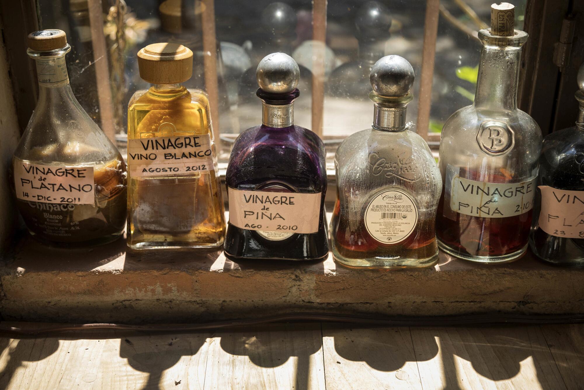 A row of bottles labeled with hand lettering.
