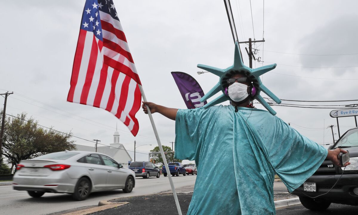 A person dressed as the Statue of Liberty tries to attract business for Liberty Tax Service